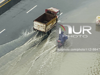 Cars are wading through a flooded road amid an orange rainstorm alert in Nanning, Guangxi Province, China, on May 8, 2024. (