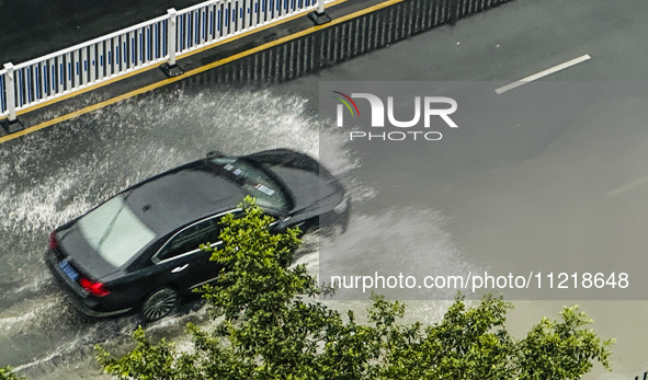 Cars are wading through a flooded road amid an orange rainstorm alert in Nanning, Guangxi Province, China, on May 8, 2024. 