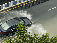 Cars are wading through a flooded road amid an orange rainstorm alert in Nanning, Guangxi Province, China, on May 8, 2024. (