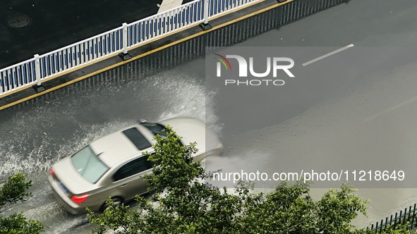 Cars are wading through a flooded road amid an orange rainstorm alert in Nanning, Guangxi Province, China, on May 8, 2024. 