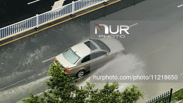 Cars are wading through a flooded road amid an orange rainstorm alert in Nanning, Guangxi Province, China, on May 8, 2024. 