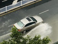 Cars are wading through a flooded road amid an orange rainstorm alert in Nanning, Guangxi Province, China, on May 8, 2024. (