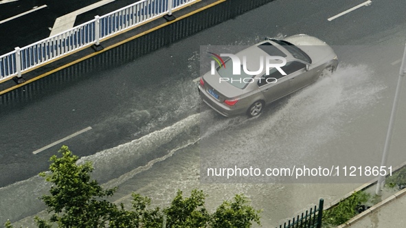 Cars are wading through a flooded road amid an orange rainstorm alert in Nanning, Guangxi Province, China, on May 8, 2024. 