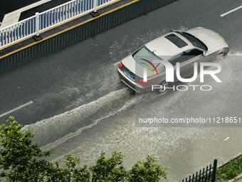 Cars are wading through a flooded road amid an orange rainstorm alert in Nanning, Guangxi Province, China, on May 8, 2024. (