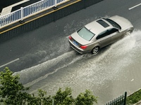 Cars are wading through a flooded road amid an orange rainstorm alert in Nanning, Guangxi Province, China, on May 8, 2024. (