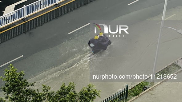 Cars are wading through a flooded road amid an orange rainstorm alert in Nanning, Guangxi Province, China, on May 8, 2024. 