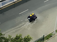 Cars are wading through a flooded road amid an orange rainstorm alert in Nanning, Guangxi Province, China, on May 8, 2024. (