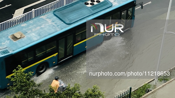 Cars are wading through a flooded road amid an orange rainstorm alert in Nanning, Guangxi Province, China, on May 8, 2024. 