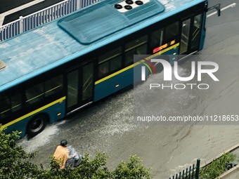 Cars are wading through a flooded road amid an orange rainstorm alert in Nanning, Guangxi Province, China, on May 8, 2024. (