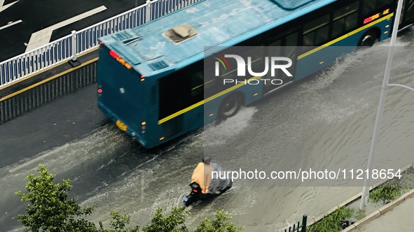 Cars are wading through a flooded road amid an orange rainstorm alert in Nanning, Guangxi Province, China, on May 8, 2024. 