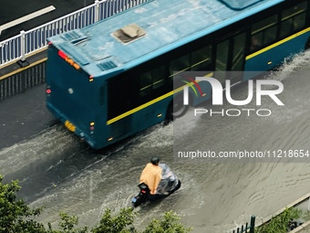 Cars are wading through a flooded road amid an orange rainstorm alert in Nanning, Guangxi Province, China, on May 8, 2024. (