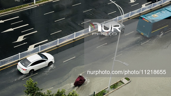 Cars are wading through a flooded road amid an orange rainstorm alert in Nanning, Guangxi Province, China, on May 8, 2024. 