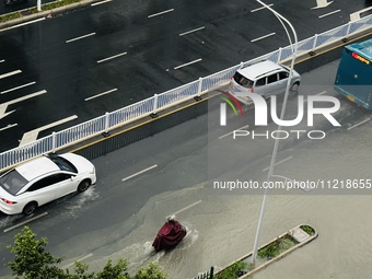 Cars are wading through a flooded road amid an orange rainstorm alert in Nanning, Guangxi Province, China, on May 8, 2024. (