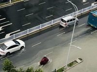 Cars are wading through a flooded road amid an orange rainstorm alert in Nanning, Guangxi Province, China, on May 8, 2024. (