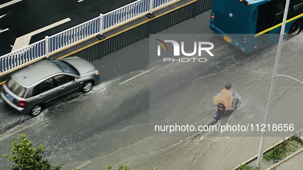 Cars are wading through a flooded road amid an orange rainstorm alert in Nanning, Guangxi Province, China, on May 8, 2024. 