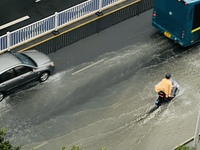 Cars are wading through a flooded road amid an orange rainstorm alert in Nanning, Guangxi Province, China, on May 8, 2024. (