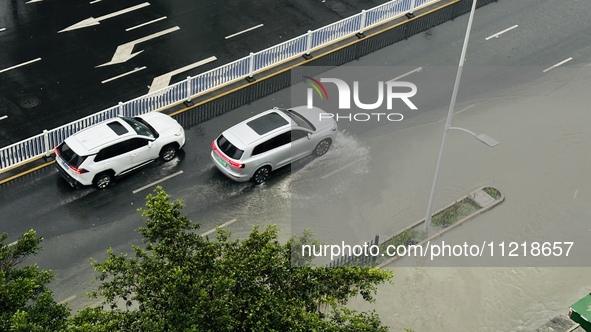 Cars are wading through a flooded road amid an orange rainstorm alert in Nanning, Guangxi Province, China, on May 8, 2024. 