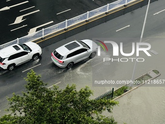 Cars are wading through a flooded road amid an orange rainstorm alert in Nanning, Guangxi Province, China, on May 8, 2024. (