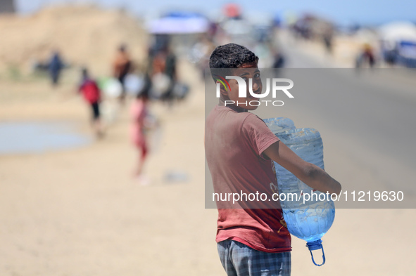 Displaced Palestinians are filling jerrycans with water at a desalination plant in Deir el-Balah in the central Gaza Strip, on May 8, 2024,...