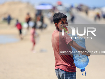 Displaced Palestinians are filling jerrycans with water at a desalination plant in Deir el-Balah in the central Gaza Strip, on May 8, 2024,...