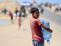 Displaced Palestinians are filling jerrycans with water at a desalination plant in Deir el-Balah in the central Gaza Strip, on May 8, 2024,...