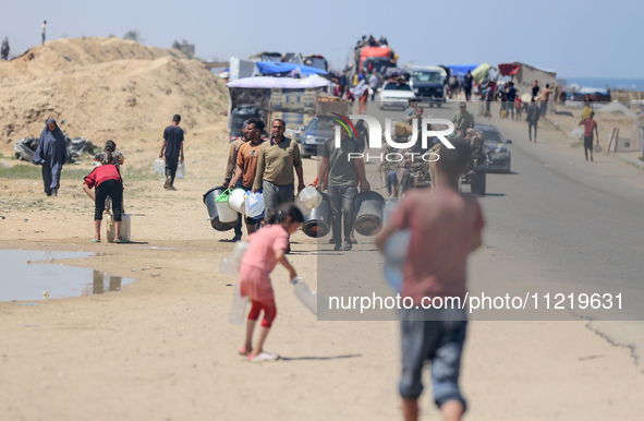 Displaced Palestinians are filling jerrycans with water at a desalination plant in Deir el-Balah in the central Gaza Strip, on May 8, 2024,...