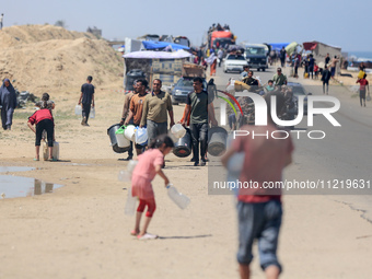 Displaced Palestinians are filling jerrycans with water at a desalination plant in Deir el-Balah in the central Gaza Strip, on May 8, 2024,...