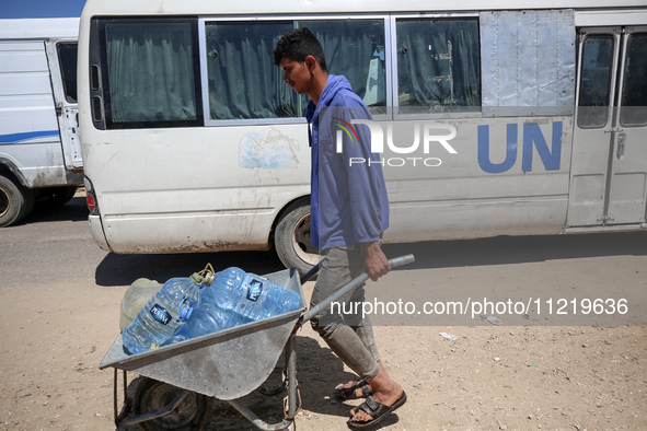 Displaced Palestinians are filling jerrycans with water at a desalination plant in Deir el-Balah in the central Gaza Strip, on May 8, 2024,...