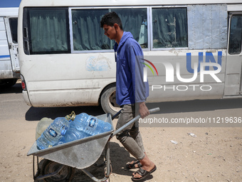 Displaced Palestinians are filling jerrycans with water at a desalination plant in Deir el-Balah in the central Gaza Strip, on May 8, 2024,...