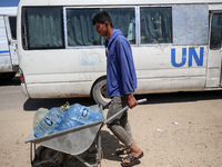 Displaced Palestinians are filling jerrycans with water at a desalination plant in Deir el-Balah in the central Gaza Strip, on May 8, 2024,...