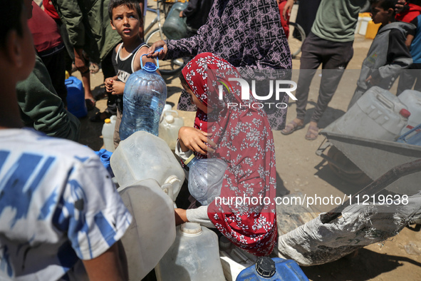 Displaced Palestinians are filling jerrycans with water at a desalination plant in Deir el-Balah in the central Gaza Strip, on May 8, 2024,...