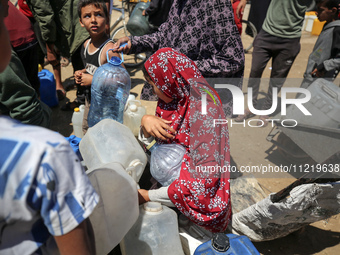 Displaced Palestinians are filling jerrycans with water at a desalination plant in Deir el-Balah in the central Gaza Strip, on May 8, 2024,...