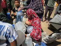 Displaced Palestinians are filling jerrycans with water at a desalination plant in Deir el-Balah in the central Gaza Strip, on May 8, 2024,...