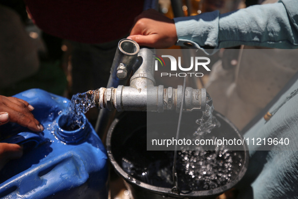 Displaced Palestinians are filling jerrycans with water at a desalination plant in Deir el-Balah in the central Gaza Strip, on May 8, 2024,...