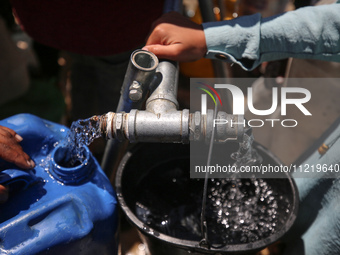 Displaced Palestinians are filling jerrycans with water at a desalination plant in Deir el-Balah in the central Gaza Strip, on May 8, 2024,...