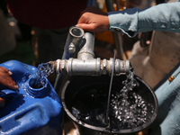 Displaced Palestinians are filling jerrycans with water at a desalination plant in Deir el-Balah in the central Gaza Strip, on May 8, 2024,...