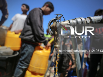 Displaced Palestinians are filling jerrycans with water at a desalination plant in Deir el-Balah in the central Gaza Strip, on May 8, 2024,...