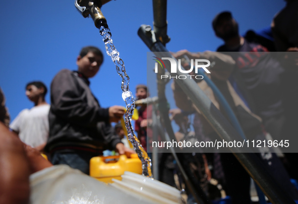 Displaced Palestinians are filling jerrycans with water at a desalination plant in Deir el-Balah in the central Gaza Strip, on May 8, 2024,...