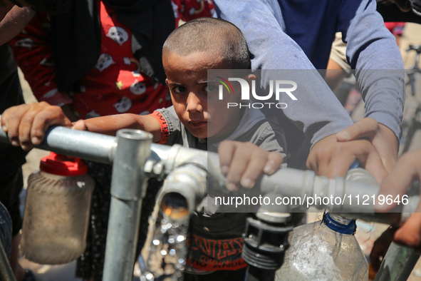 Displaced Palestinians are filling jerrycans with water at a desalination plant in Deir el-Balah in the central Gaza Strip, on May 8, 2024,...