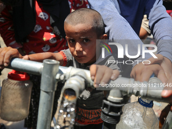 Displaced Palestinians are filling jerrycans with water at a desalination plant in Deir el-Balah in the central Gaza Strip, on May 8, 2024,...