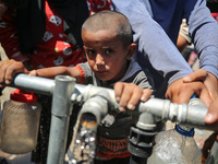 Displaced Palestinians are filling jerrycans with water at a desalination plant in Deir el-Balah in the central Gaza Strip, on May 8, 2024,...