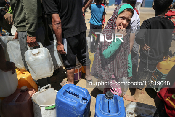 Displaced Palestinians are filling jerrycans with water at a desalination plant in Deir el-Balah in the central Gaza Strip, on May 8, 2024,...