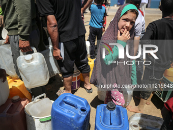 Displaced Palestinians are filling jerrycans with water at a desalination plant in Deir el-Balah in the central Gaza Strip, on May 8, 2024,...