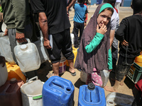 Displaced Palestinians are filling jerrycans with water at a desalination plant in Deir el-Balah in the central Gaza Strip, on May 8, 2024,...