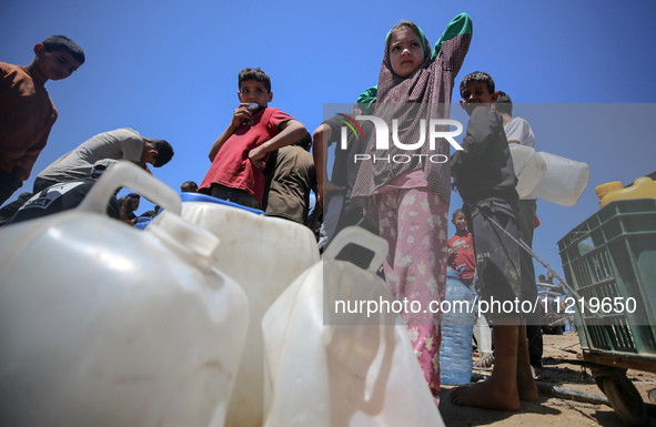 Displaced Palestinians are filling jerrycans with water at a desalination plant in Deir el-Balah in the central Gaza Strip, on May 8, 2024,...