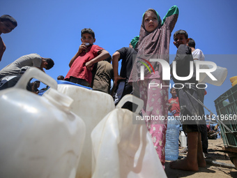 Displaced Palestinians are filling jerrycans with water at a desalination plant in Deir el-Balah in the central Gaza Strip, on May 8, 2024,...