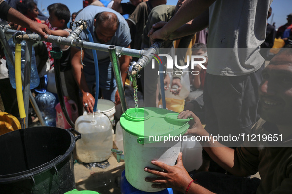 Displaced Palestinians are filling jerrycans with water at a desalination plant in Deir el-Balah in the central Gaza Strip, on May 8, 2024,...