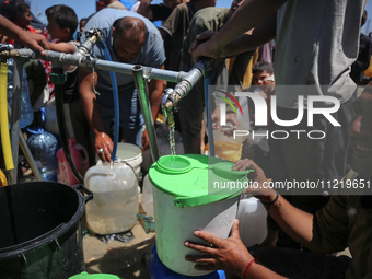 Displaced Palestinians are filling jerrycans with water at a desalination plant in Deir el-Balah in the central Gaza Strip, on May 8, 2024,...