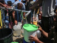 Displaced Palestinians are filling jerrycans with water at a desalination plant in Deir el-Balah in the central Gaza Strip, on May 8, 2024,...