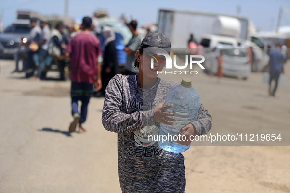 Displaced Palestinians are filling jerrycans with water at a desalination plant in Deir el-Balah in the central Gaza Strip, on May 8, 2024,...